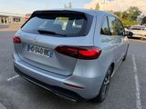 the rear end of a silver car parked in a parking lot