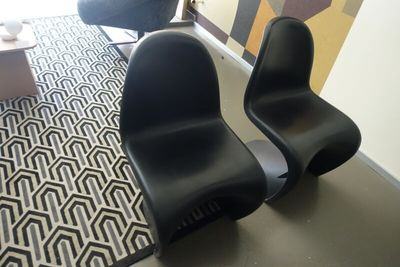 two black chairs sitting in a room with a rug on the floor