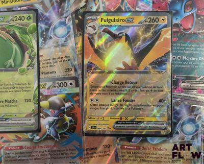 several pokemon cards sitting on top of each other on a table