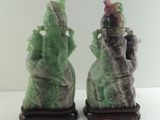 two green and purple vases sitting on a table