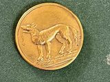 une pièce d'or sur laquelle est représenté un chien