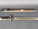two knives are laying side by side on a gray surface