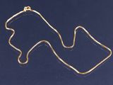 un collier en or sur un fond bleu, avec une chaîne en or