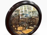 un miroir rond dans lequel se reflète une salle à manger