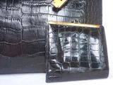 a black purse and a black purse on a white table