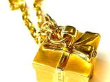 a gold gift box with a bow on a chain