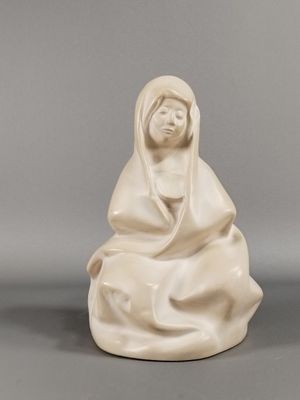une statue blanche représentant une femme assise par terre