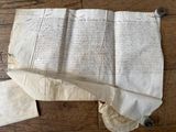 un vieux papier sur lequel il y a des inscriptions, posé sur un plancher en bois