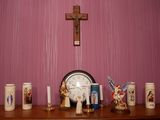 une étagère en bois sur laquelle sont posés une horloge, des bougies et des figurines