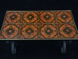 an orange and black table with a black base and black legs