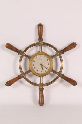 une horloge accrochée au mur en forme de barre à roue