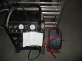 a picture of a portable air compressor with a hose and gauges