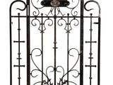 a black iron gate with a clock on top of it