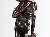 une image représentant la statue d'un homme avec un bol sur la tête