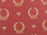 a close up of a red and gold wallpaper with a wreath pattern