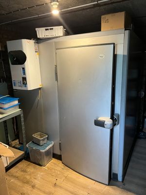 a refrigerator in a room with a lot of boxes on the floor