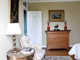 une pièce dans laquelle se trouvent un lit, une chaise et une commode