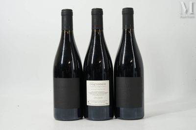trois bouteilles de vin rouge sont posées sur une surface blanche