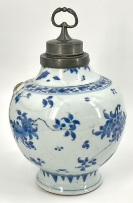 a blue and white vase with a metal lid