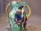 a blue and green vase with a fish design on it