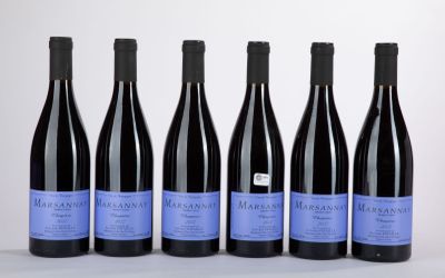 six bottles of wine are lined up on a white surface
