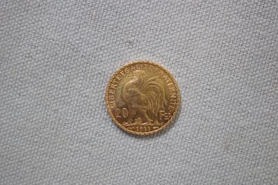 gros plan d'une pièce d'or sur une surface blanche