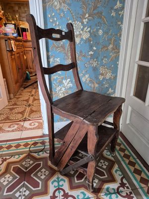 une chaise en bois posée devant une porte dans une pièce