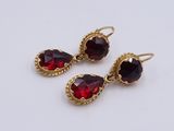 three pairs of garnets on a white surface
