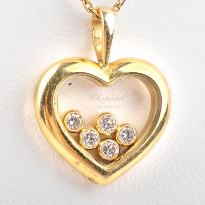 an image of a heart shaped pendant with three diamonds in it