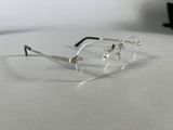 a pair of glasses sitting on a table with a laptop in the background