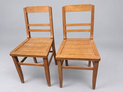 deux chaises en bois placées l'une à côté de l'autre sur une surface grise