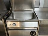 une cuisinière en acier inoxydable et un évier dans une cuisine professionnelle