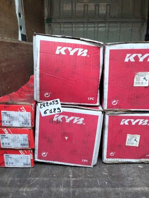 Plusieurs cartons sont empilés les uns sur les autres par terre.