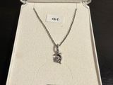 une boîte blanche posée sur une table, contenant un collier en argent