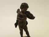 une petite statue représentant un garçon avec un oiseau sur l'épaule