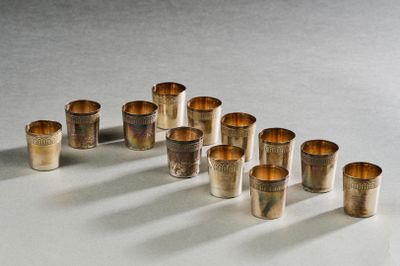 Plusieurs coupes en argent sont alignées en rangée sur une surface blanche