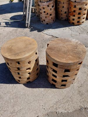 three wooden stools sitting on top of a cement floor next to a bicycle