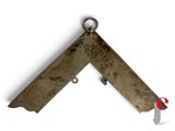 an old knife hanging on a hook on a white wall