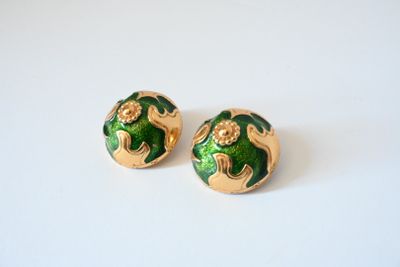pair of green and gold earrings on a white surface
