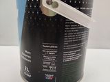 a can of paint with a white handle on a table