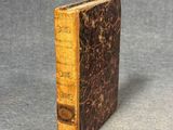 an old book sitting on top of a table next to a gray surface