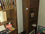 une bibliothèque avec des livres posés dessus, dans un coin de la pièce