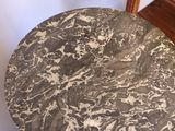 a black and white marble table with a wooden base