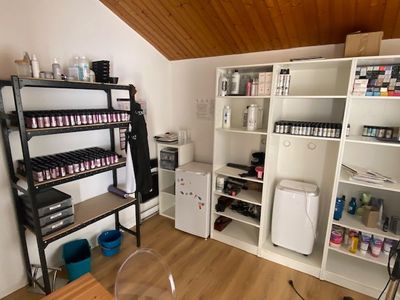 une pièce équipée d'un bureau, d'étagères et d'un réfrigérateur