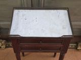 an antique marble topped table with two drawers on top of it