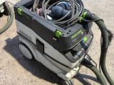 a vacuum that is sitting on the ground next to a hose