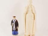 a figurine of a man standing next to a statue of a woman