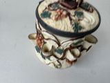 a ceramic box with a bird on it on a table