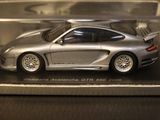 a silver toy car in a clear box on a table