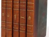 trois livres en cuir marron sont empilés les uns sur les autres